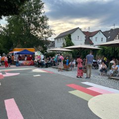 eine Straße mit einer Holzhütte und Menschen, die sich dort aufhalten