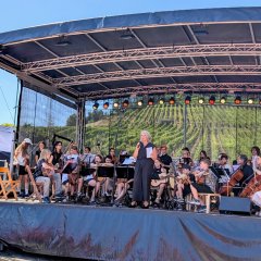 Die Leiterin der städtischen Musikschule Weinsberg mit dem Orchester der Musikschule auf einer Bühne