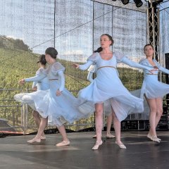 5 Balletttänzerinnen mit hellblauem Klein, die auf einer Bühne tanzen