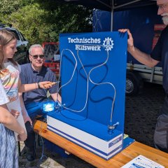 Das Bild zeigt ein Mädchen, das an der Mitmachstation den Technischen Hilfswerk versucht eine Öse über einen Draht zu bewegen ohne diesen zu berühren