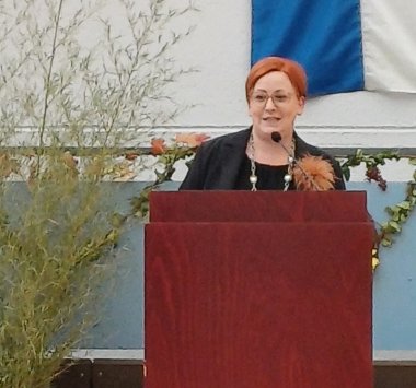 Bürgermeisterin Birgit Hannemann steht am festlich geschmückten Bühnenpult und begrüßt die Gäste