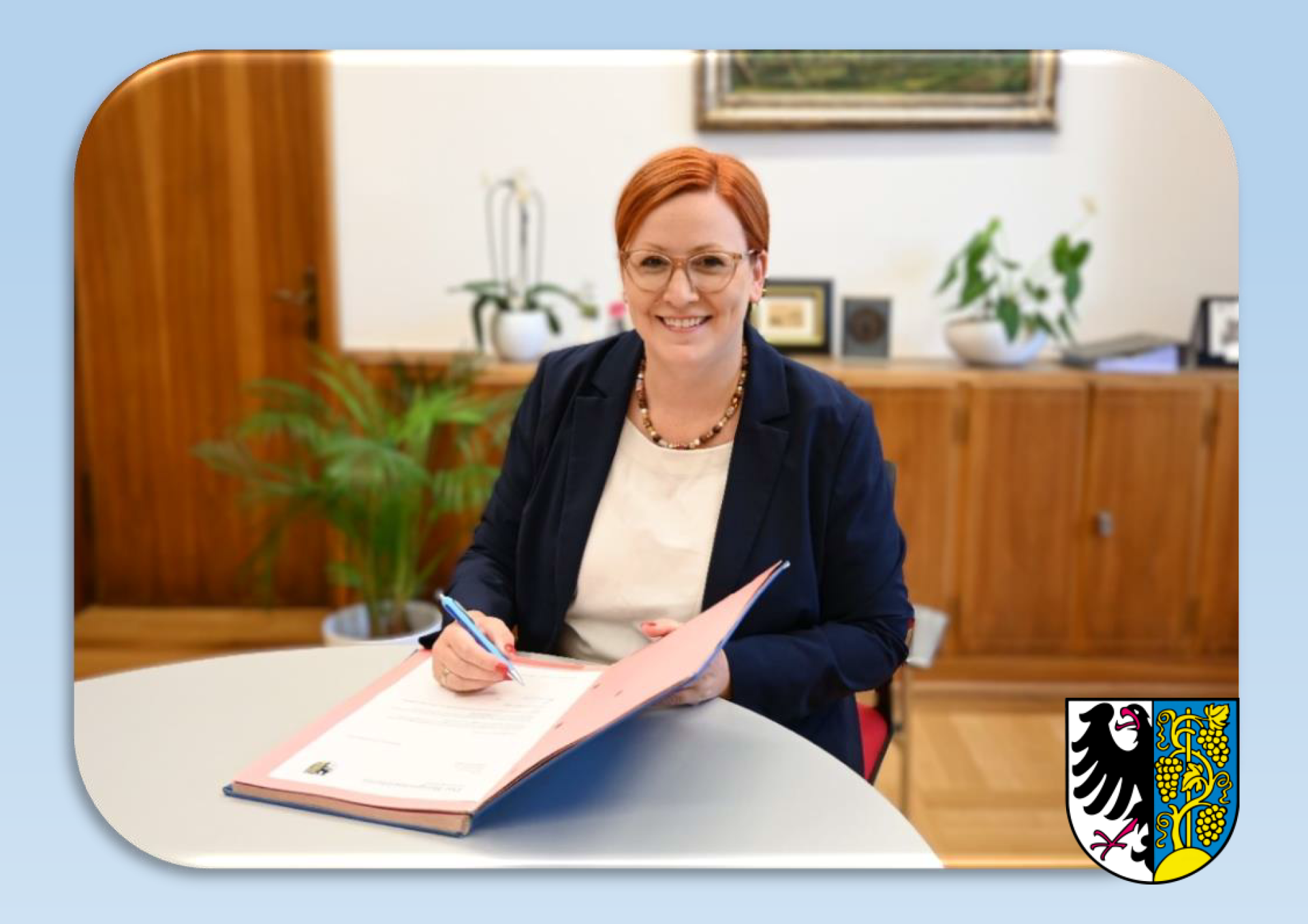 Weinsbergs Bürgermeisterin Birgit Hannemann sitzt an einem Tisch und unterschreibt ein Dokument.