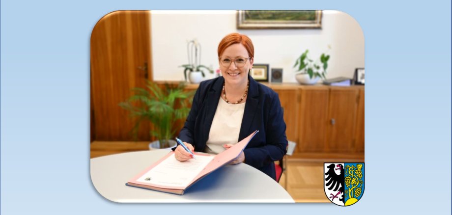 Die Bürgermeisterin der Stadt Weinsberg Birgit Hannemann sitzt an einem Tisch und unterschreibt ein Dokument